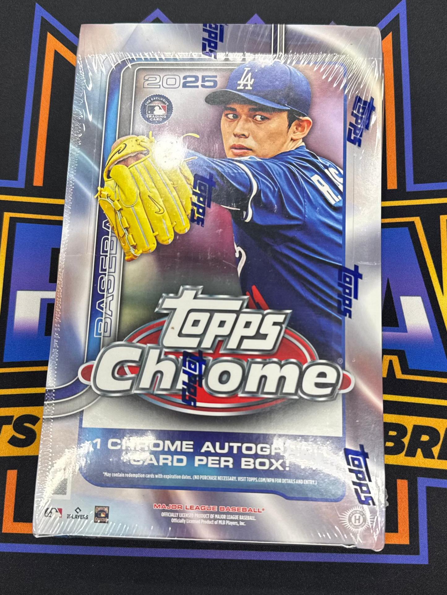 Topps Chrome baseball trading card packaging on a black background with branding.